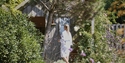 a woman in a robe walking to a spa retreat in a garden