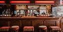 Bar area inside the First In Last Out pub in Hastings with real ale pumps and wooden seating.