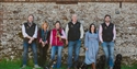 Team members and dogs gathered outside a traditional flint wall at Charles Palmer Vineyards.