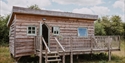Starcroft Farm Cabin with timber cladding and a raised deck, surrounded by peaceful countryside.