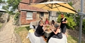 Guests enjoy outdoor dining with Vine & Country Tours in a rustic Sussex garden setting.