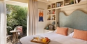 Elegant guest room at The Gallivant with garden terrace, reading nook and breakfast tray.