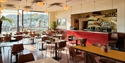 Sunlit café inside Hastings Contemporary with tables, chairs and views across Hastings seafront.