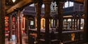 Ornate gallery at Hastings Museum & Art Gallery with carved wooden columns and historic displays.