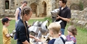 Visitors exploring medieval armour and helmets during a hands-on activity at Bodiam Castle.