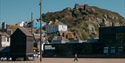 Hastings Contemporary gallery beneath East Hill cliffs, with Old Town buildings and fishing huts nearby.