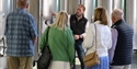 Visitors on a guided winery tour at Charles Palmer Vineyards beside stainless steel fermentation tanks.