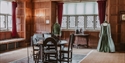 Historic wood-panelled room at Michelham Priory with period furniture and Tudor-style costumes.