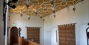 Ornate interior corridor inside Herstmonceux Castle featuring vaulted ceiling and wooden balcony.
