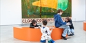 Children drawing and creating artwork in a Hastings Contemporary gallery beside a large colourful painting.