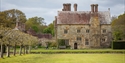 Bateman’s house and gardens in East Sussex, with historic stone façades and neatly clipped lawns.