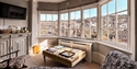 Bright guest lounge at The Laindons with bay windows, seating area and views over Hastings Old Town rooftops.