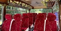 Inside of 1967 Bedford 20 seat classic coach pictured with red seats and decorative wedding flowers