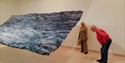 sitors exploring a large wave-inspired art installation at Hastings Contemporary.