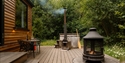 Wood-fired hot tub and outdoor seating beside a woodland cabin at Downash Wood.