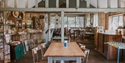 Vintage-style café interior at Michelham Priory with rustic furnishings, games and communal seating.