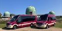 2 Empress Coaches vehicles, both burgundy with a cream stripe, parked outside The Observatory Science Centre in Herstmonceux