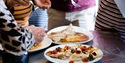 freshly prepared seafood being tasted, photograph only shows hands and forks moving towards the plates.