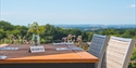 reserved garden table overlooking far reaching countryside views, with blue sky.