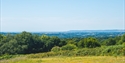 a green field and blue sky with far reaching views.