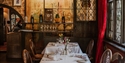 Elegant dining room at The Mermaid Inn, featuring period décor, leaded windows and set tables.