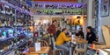 Copilot said:

Noah’s Goat wine bar in Hastings, with shelves of wine bottles and customers enjoying drinks in a cosy setting