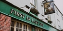 Exterior of the First In Last Out pub in Hastings with traditional signage and green frontage.
