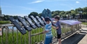 Children play an outdoor sound exhibit at The Observatory Science Centre with telescope dome and pond in the background.