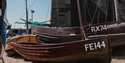 Traditional fishing boats displayed beside Hastings net huts at Hastings Fishermen’s Museum.