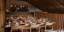 Elegant indoor tasting room at Gusbourne Estate set with tables, wine glasses, and warm wood interiors.