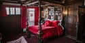 Historic four-poster bedroom at The Mermaid Inn, with carved wood panelling and period furnishings.