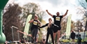 Pictures shows two adults crossing the finish line of a running event with a child waiting for them