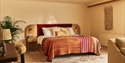 Image shows the inside of one of the bedrooms at Crafted at Powdermills. The Room is bright, light and neutral tones. The bed is in the centre of the