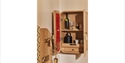 Image shows the inside of one of the bedrooms at Crafted at Powdermills, showing an open cupboard that is on the wall. Inside the cupboard is the tea
