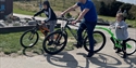 A man and two children on bicycles.