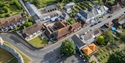 Aerial view of the Mint House in Pevensey, showing the main building and surrounding village / castle walls.