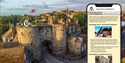 scenic aerial view of Rye, a historic town in East Sussex, England. The foreground shows the medieval stone gateway known as Landgate, with two round