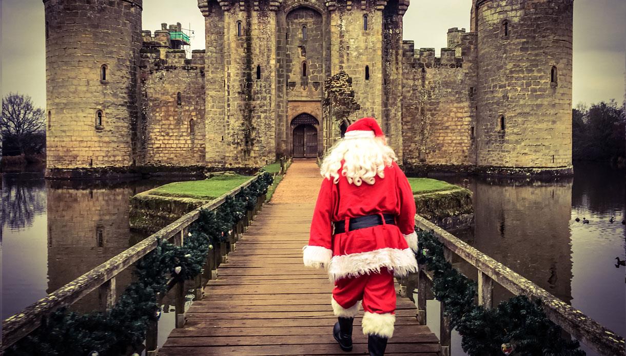 Father Christmas walking over the bridge to Bodiam Castle