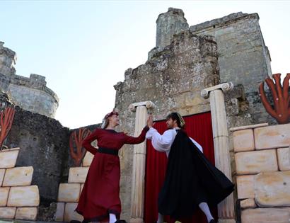 medieval style actors in the grounds of a castle.