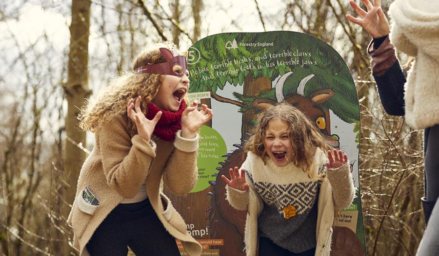 Two children roaring like a gruffalo in the woods. For an even at Bedgebury Pinetum.
