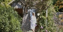 a woman in a robe walking to a spa retreat in a garden