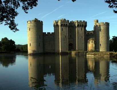 Turreted castle on large moat with reflection