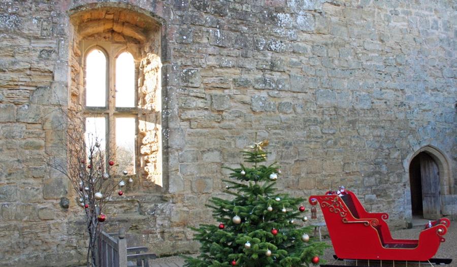 old castle wall with red santa sleigh and christmas tree