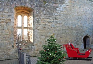 old castle wall with red santa sleigh and christmas tree