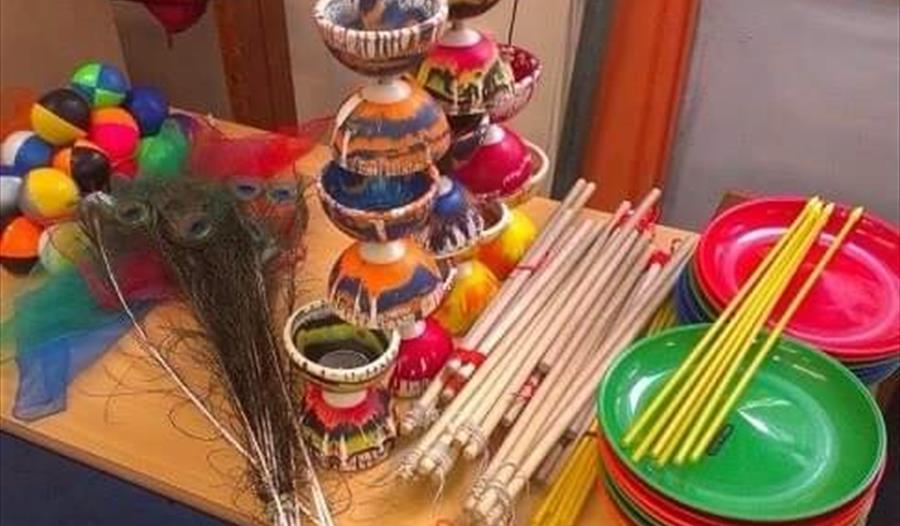 table full of circus items including spinning plates sticks juggling balls and diablo