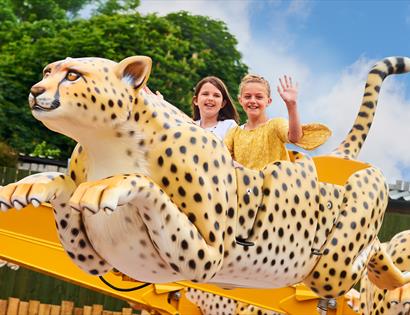Children on a leopard funfair ride at Drusillas Park, Alfriston, East Sussex