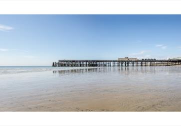 Hastings Pier at low tide viewed from the beach on the eastern side