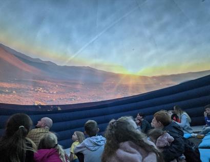 children sitting inside a planetarium