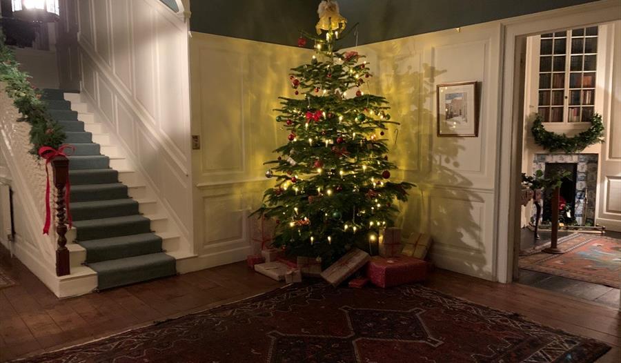 panelled hallway with christmas tree glowing