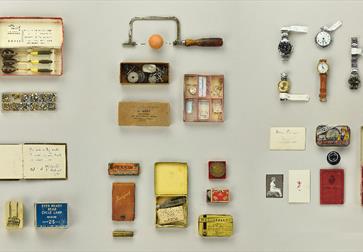 A collection of objects and memorabilia, laid out in block formation.